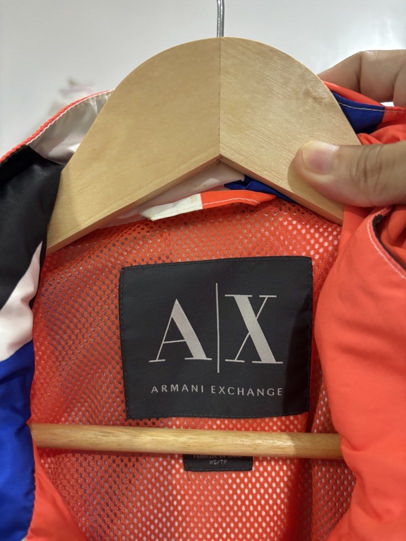 Armani Exchange Colorblock Windbreaker Jacket (Category: Coats, Jackets and Outerwear) located in Calbayog City. Submitted by zaxcheus_castillo1708 (Listing ID 1469669001, Image 2). Description: - Brand: Armani Exchange - Type: Zip-up windbreaker jacket - Size: XS - Design: Vibrant red, blue, black, and white geometric colorblock - Interior: Bright orange mesh lining - Features: High collar, full zip closure, and front utility pockets - Style: Co