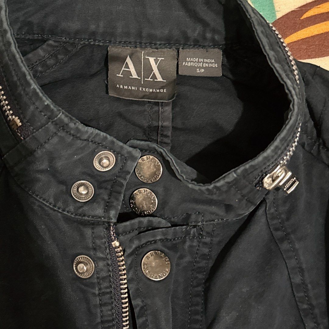 Armani Exchange Jacket Size S (Category: Coats, Jackets and Outerwear) located in Manila. Submitted by jeromepsg12 (Listing ID 1469596659, Image 2). Description: Authentic Armani Exchange dark blue jacket in Size S. Features a stylish stand collar with snap buttons, front zipper, silver hardware, and ribbed panels on the shoulders and sleeves..