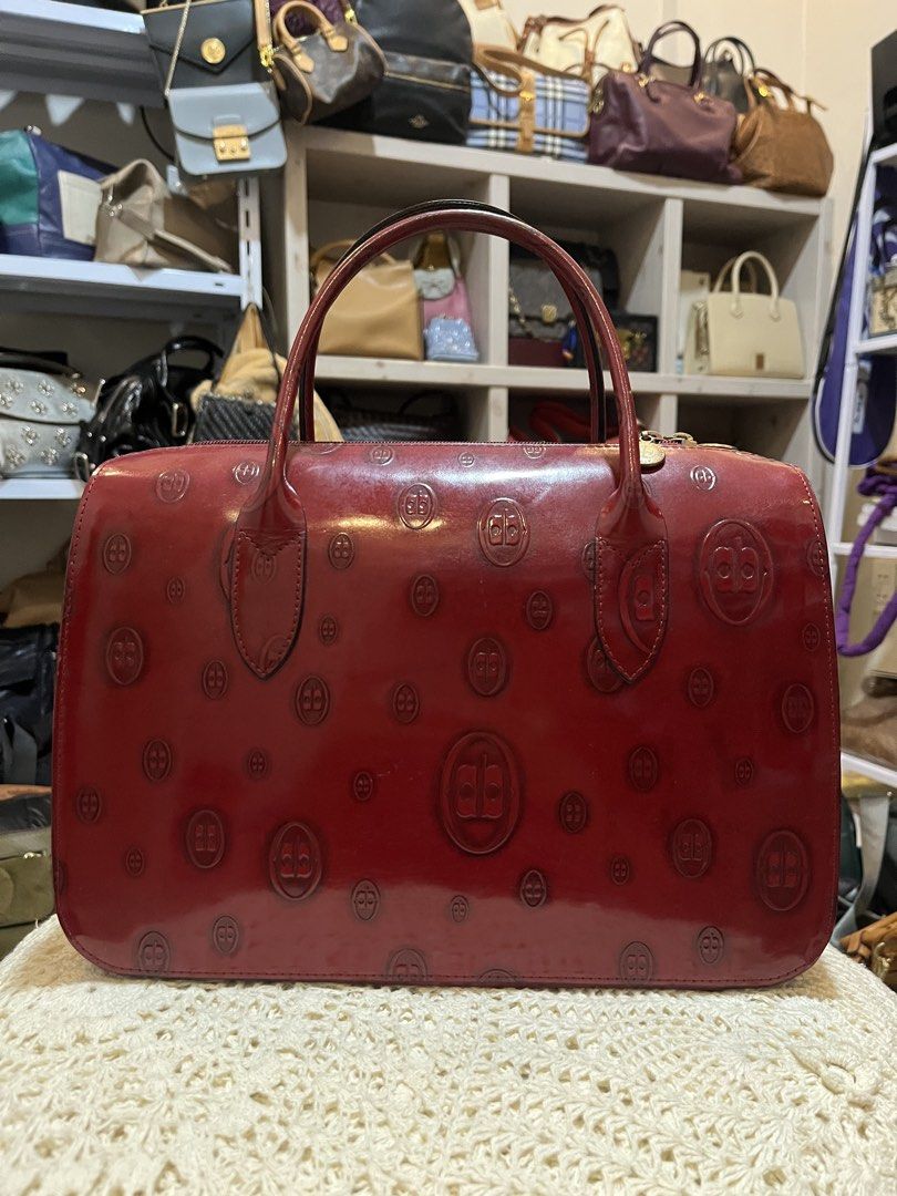 Arnaldo Bassini Red Leather Monogram Handbag (Category: Luxury Bags & Wallets) located in Bacolod City. Submitted by vintage_vogue6100 (Listing ID 1469671457, Image 3). Description: - Brand: Arnaldo Bassini Italy - Color: Rich red - Material: Premium leather with all-over debossed monogram pattern - Design: Structured shape with dual top handles and gold hardware zipper pulls - Measurements: 31cm (L) x 22cm (H) x 12cm (W) .
