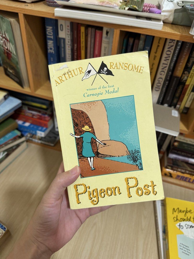 Arthur Ransome Pigeon Post Paperback (Category: Storybooks) located in Quezon City. Submitted by mm_dxm (Listing ID 1469590344, Image 1). Description: - Title: Pigeon Post by Arthur Ransome - Accolade: Winner of the first-ever Carnegie Medal - Format: Paperback with a classic yellow cover - Condition: Minor wear on the top left corner of the cover; pages have natural yellowing due to age - Genre: Timeless adventure story, perfect for collectors a