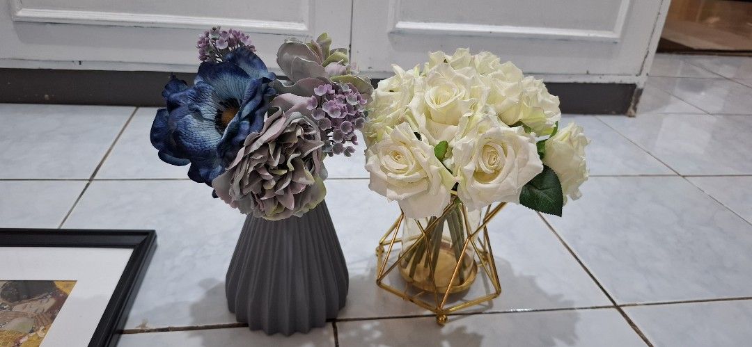 Artificial Flower Vases Set Home Decor (Category: Vases & Decorative Bowls) located in Paranaque City. Submitted by finders_thriftersph (Listing ID 1469573537, Image 1). Description: - Set of 2 ready-to-display decorative vases with artificial flowers - Left vase: Grey ribbed ceramic holding vibrant blue and purple blooms - Right vase: Geometric gold metal frame with glass cylinder holding classic white roses - Versatile centerpiece ideal for din