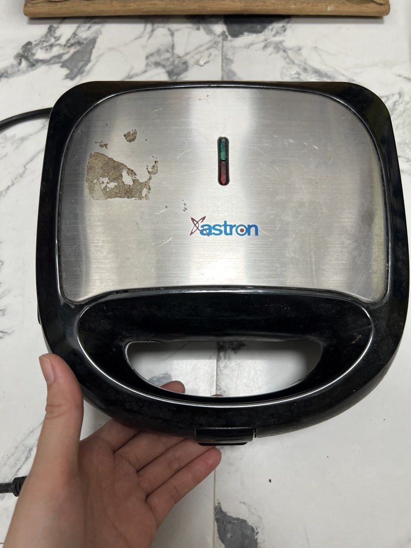 Astron SM-400 Sandwich Maker Griller (Category: Cookware & Accessories) located in Manila. Submitted by jeanmanlapig.f6bd51 (Listing ID 1469706378, Image 1). Description: Used once only - Brand/Model: Astron SM-400 Sandwich Maker - Color: Black body with silver top plate - Power: AC220-240V, 50/60Hz, 750W - Size: Approx. 23.7cm x 23cm x 9.2cm - Condition: Powers on and works fine; has minor scratches and sticker residue on the stainless steel lid