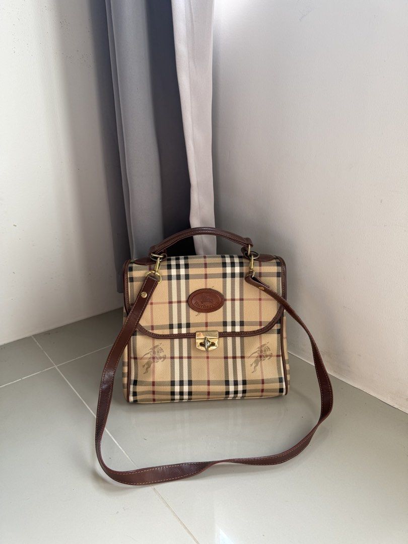 Authentic Burberry Top Handle Bag (Category: Luxury Bags & Wallets) located in Quezon City. Submitted by luxurybags.ph_official2017 (Listing ID 1469712631, Image 3). Description: - Authentic Burberry top handle bag - Iconic classic check pattern with rich brown leather trim - Elegant gold-tone hardware with secure clasp closure - Features the vintage oval Burberrys logo badge on front - Includes a convenient detachable shoulder strap - Onhand and