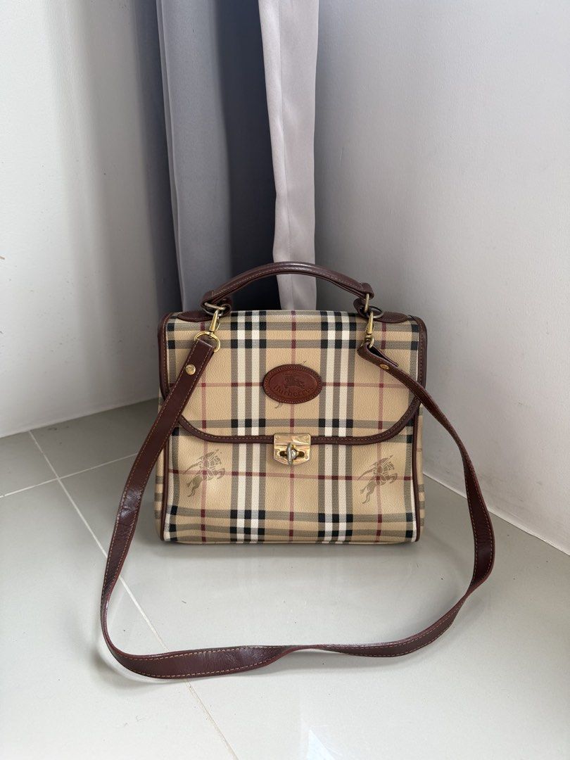 Authentic Burberry Top Handle Bag (Category: Luxury Bags & Wallets) located in Quezon City. Submitted by luxurybags.ph_official2017 (Listing ID 1469712631, Image 2). Description: - Authentic Burberry top handle bag - Iconic classic check pattern with rich brown leather trim - Elegant gold-tone hardware with secure clasp closure - Features the vintage oval Burberrys logo badge on front - Includes a convenient detachable shoulder strap - Onhand and