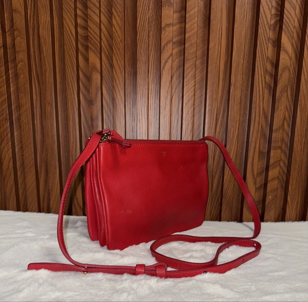 Authentic Celine Red Trio Crossbody Bag (Category: Everything Else Others) located in Subic. Submitted by luxshoppe88 (Listing ID 1469708884, Image 2). Description: - Authentic bright red Celine Trio bag - Crafted from smooth leather with clean fabric lining - Features three zippered compartments that snap together - Adjustable long thin strap with buckle closure - Elegant gold-tone hardware and front Celine logo stamp - Versatile and lightweight