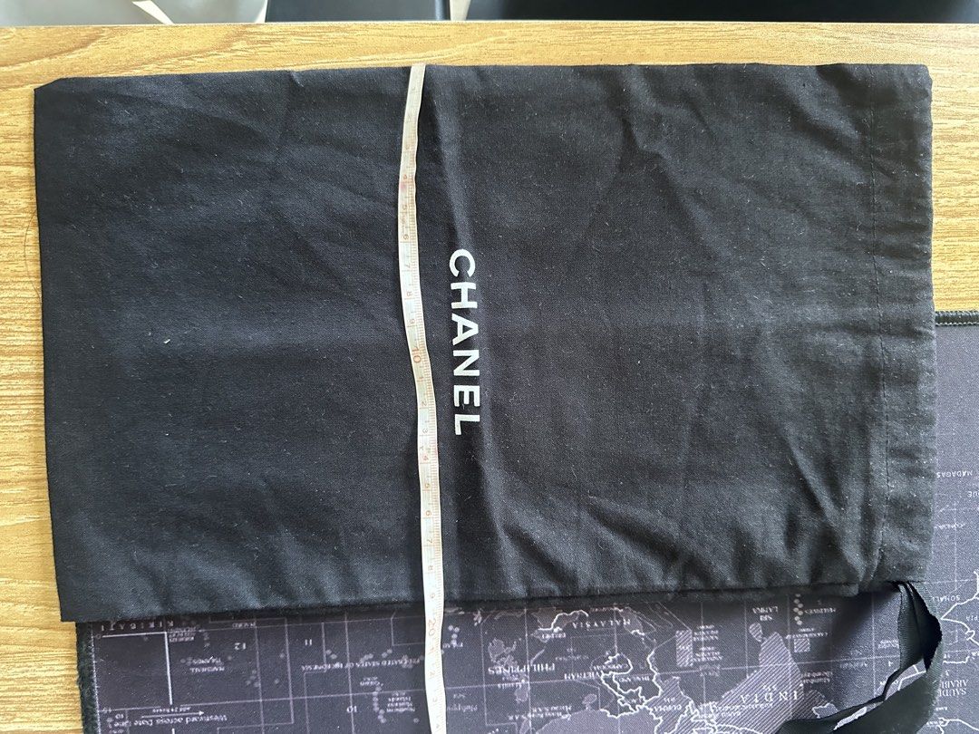 Authentic CHANEL Black Drawstring Dust Bag 34x22cm (Category: Luxury Bags & Wallets) located in Los Banos. Submitted by bianxster (Listing ID 1469576595, Image 3). Description: - Authentic Chanel dust bag - Color: Classic black with white front logo - Material: Clean, high-quality cotton - Closure: Secure top drawstring - Size: Approximately 34cm x 22cm - Condition: Excellent, clean, no stains or damage.