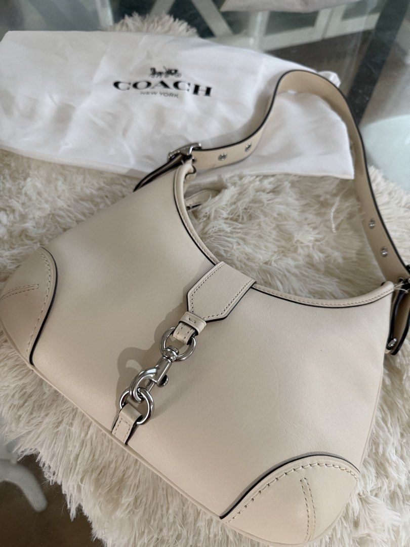 Authentic Coach Hampton Hobo Bag (Category: Luxury Bags & Wallets) located in Manila. Submitted by bagluxeph (Listing ID 1469711298, Image 1). Description: - Brand: Coach - Color: Off-white - Material: Genuine leather with brown leather interior - Hardware: Silver-tone - Closure: Dog leash clip - Strap: Adjustable with buckle detail - Interior: Features official Coach creed patch - Inclusions: Dust bag included Used once - Like new condition.
