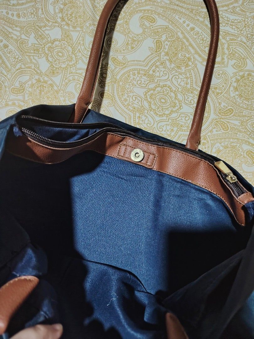 Authentic Legato Largo (Category: Tote Bags) located in Antipolo. Submitted by gmariola101 (Listing ID 1469605691, Image 3). Description: Authentic Legato Largo Tote Blue nylon tote bag with brown faux leather handles and secure zip-and-snap closure. Features a clean dark blue interior with extra pockets. Perfect everyday shoulder bag for work or school..
