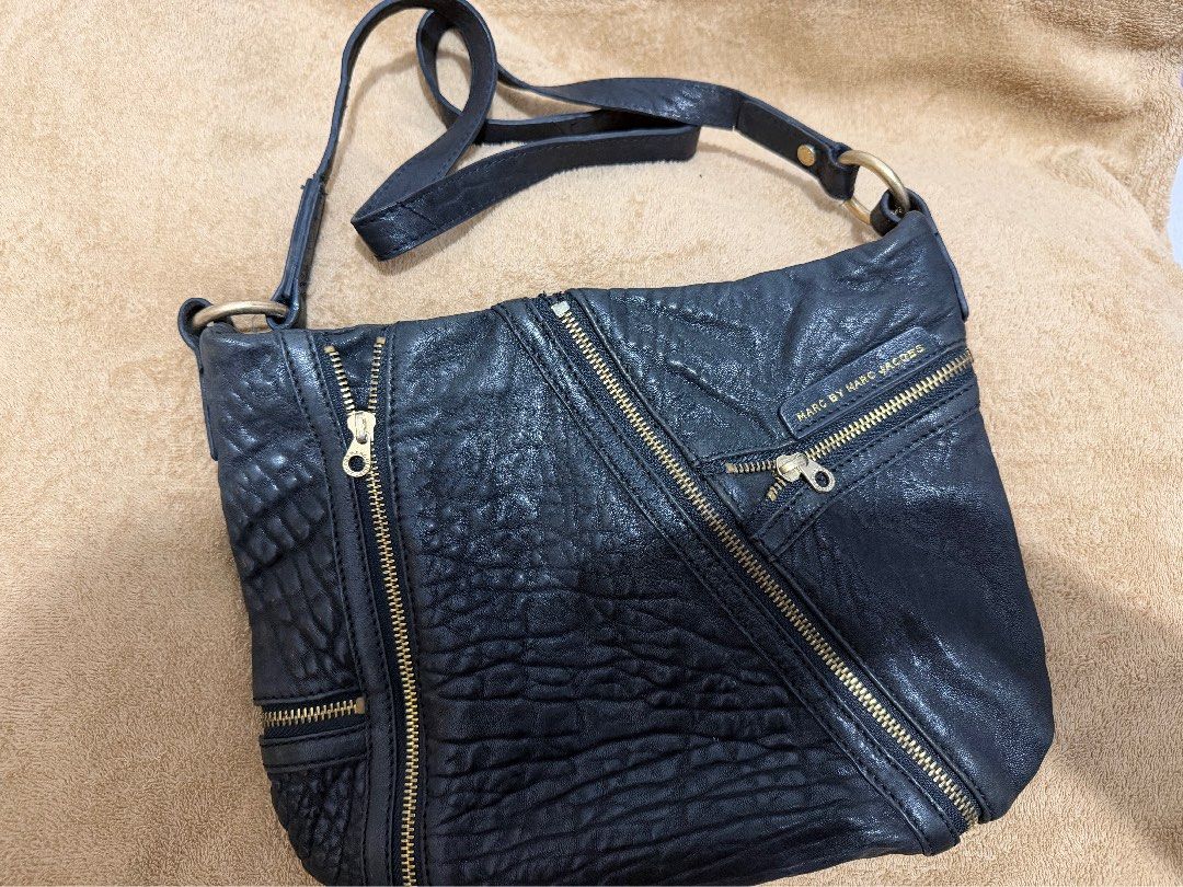 Authentic Marc Jacobs Black Leather Crossbody Bag (Category: Cross-body Bags) located in Quezon City. Submitted by skyleeeee (Listing ID 1469582745, Image 1). Description: - Authentic Marc by Marc Jacobs - Color: Classic Black with gold-tone hardware - Material: Premium pebbled textured leather - Storage: Roomy interior with multiple convenient front zipped pockets - Details: Distinctive large branded metal ring strap connectors and signature log