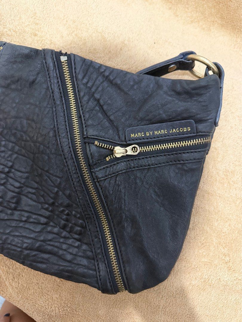 Authentic Marc Jacobs Black Leather Crossbody Bag (Category: Cross-body Bags) located in Quezon City. Submitted by skyleeeee (Listing ID 1469582745, Image 2). Description: - Authentic Marc by Marc Jacobs - Color: Classic Black with gold-tone hardware - Material: Premium pebbled textured leather - Storage: Roomy interior with multiple convenient front zipped pockets - Details: Distinctive large branded metal ring strap connectors and signature log