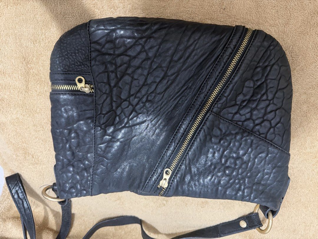 Authentic Marc Jacobs Black Leather Crossbody Bag (Category: Cross-body Bags) located in Quezon City. Submitted by skyleeeee (Listing ID 1469582745, Image 3). Description: - Authentic Marc by Marc Jacobs - Color: Classic Black with gold-tone hardware - Material: Premium pebbled textured leather - Storage: Roomy interior with multiple convenient front zipped pockets - Details: Distinctive large branded metal ring strap connectors and signature log