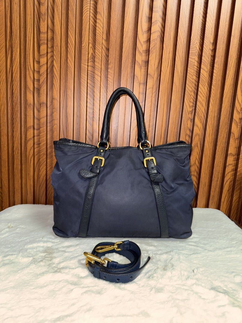 Authentic Prada Nylon Tote Bag with Leather Straps and Gold Hardware (Category: Luxury Bags & Wallets) located in Subic. Submitted by luxshoppe88 (Listing ID 1469700233, Image 3). Description: - Authentic Prada nylon tote bag in a versatile dark blue shade - leather top handles, vertical strap details, and gleaming gold-tone hardware - Removable matching shoulder strap for versatile styling (handbag or crossbody) - Iconic gold Prada Milano logo f