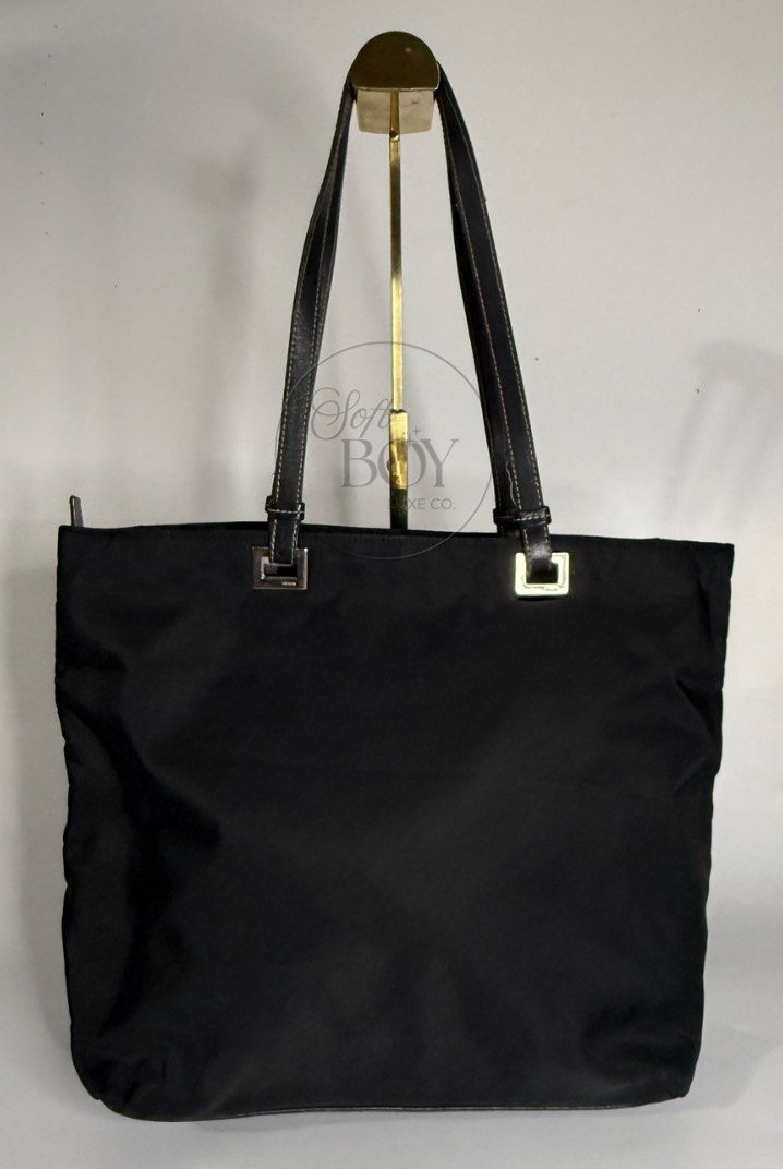 Authentic Prada Tessuto Nylon Tote Bag – Black (Category: Luxury Bags & Wallets) located in Manila. Submitted by raymondabigan (Listing ID 1469634376, Image 3). Description: Authentic Prada Tessuto Nylon Tote Bag – Black A classic Prada nylon tote bag in black, featuring the iconic triangular logo plaque, leather shoulder straps, and silver-tone hardware. Complete with a spacious interior, zippered closure, and leather base, this vintage piece of