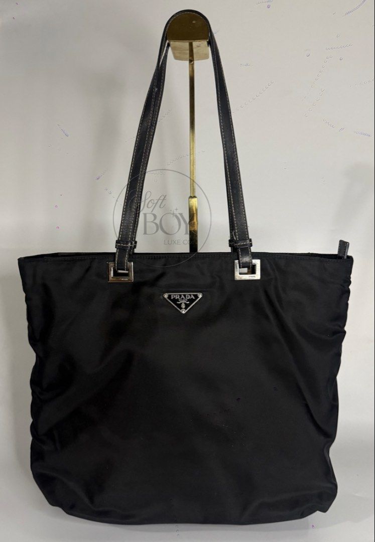 Authentic Prada Tessuto Nylon Tote Bag – Black (Category: Luxury Bags & Wallets) located in Manila. Submitted by raymondabigan (Listing ID 1469634376, Image 1). Description: Authentic Prada Tessuto Nylon Tote Bag – Black A classic Prada nylon tote bag in black, featuring the iconic triangular logo plaque, leather shoulder straps, and silver-tone hardware. Complete with a spacious interior, zippered closure, and leather base, this vintage piece of