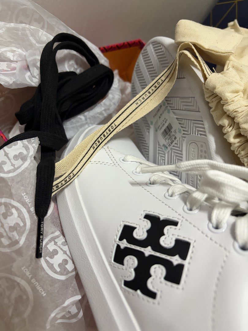 Authentic Tory Burch White and Black Leather Sneakers (Category: Sneakers & Footwear) located in Taguig. Submitted by labellearmoire2 (Listing ID 1469660245, Image 3). Description: Got it from rustan’s, used once. Has the white laces with extra free black laces. With dustbag & box. Originally bought for around 15k more or less. - Brand: Tory Burch - Color: White and Black with iconic double T logo on the side - Design: Contrast black heel tab wit