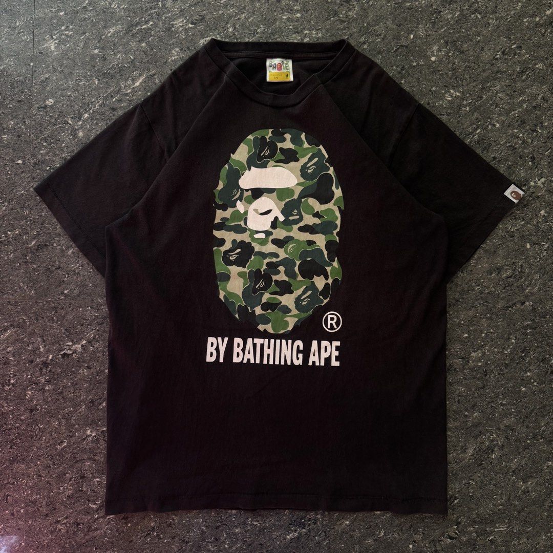 Bape head tee (Category: Formal Shirts) located in Bulacan. Submitted by b4mzz (Listing ID 1469639622, Image 2). Description: BAPE Camo Ape Head Tee 🦍 Classic black tee with iconic camo graphic. Perfect for streetwear fits. 📏 Width: 21.5” | Length: 28” 🎨 Color Rate: 8.5/10 ⚠️ Issue: Fading 💬 Open for reasonable offers!.
