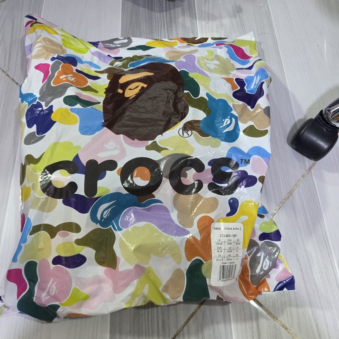 BAPE x Crocs Echo Clogs Multi Color (Category: Slippers & Slides) located in Manila. Submitted by sik2find (Listing ID 1469706610, Image 2). Description: -SIZE M5 - Brand new with tags in original packaging bag - Authentic BAPE x Crocs Echo Clogs collaboration - Multi-color camo pattern with glow-in-the-dark material - Includes extra Jibbitz charms pack (Ape Head, BAPE logo, and bee design) - Men Size M6/W8 (EU 38-39) - 100% authentic and ready t
