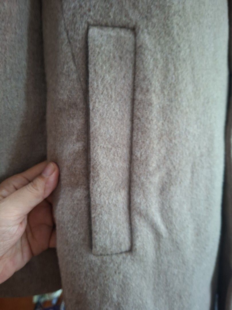 Beige woolen trench coat winter outerwear (Category: Coats, Jackets and Outerwear) located in Quezon City. Submitted by apple.ana888 (Listing ID 1469628463, Image 3). Description: - Color: Elegant beige - Material: Warm wool-blend, fully lined interior - Style: Double-breasted front with two dark buttons and classic lapel collar - Length: Medium - Features: Two functional front pockets - Condition: Great for cold weather layering.