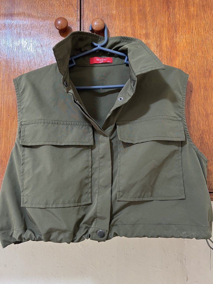 Bench Olive Green Crop Vest Size Large (Category: Sleeveless) located in Makati City. Submitted by sheenaxxxx (Listing ID 1469605828, Image 1). Description: - Brand: Bench - Size: Large - Color: Olive green - Style: Crop with collared neckline - Pockets: Two large front flap chest pockets - Hem: Elasticated with adjustable side drawstrings - Material: Smooth, comfortable fabric.