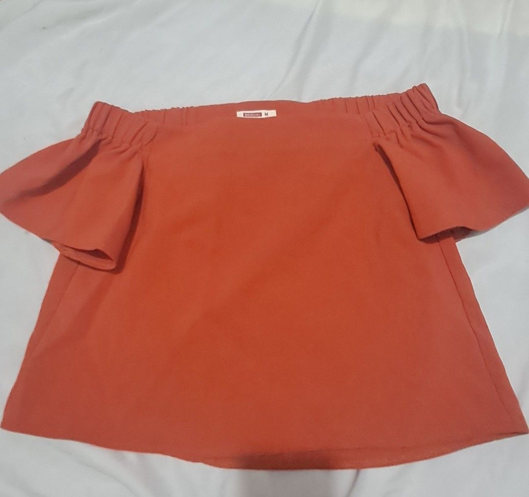 Bench Orange Off Shoulder Top Size M (Category: Blouses) located in Antipolo. Submitted by happyhoney26 (Listing ID 1469690557, Image 1). Description: - Brand: Bench - Size: Medium (tag attached) - Color: Bright orange - Style: Off-shoulder with short ruffled sleeves and elasticated neckline - Material: Soft fabric - Condition: Great for casual wear, summer days, and easily matched with denim.