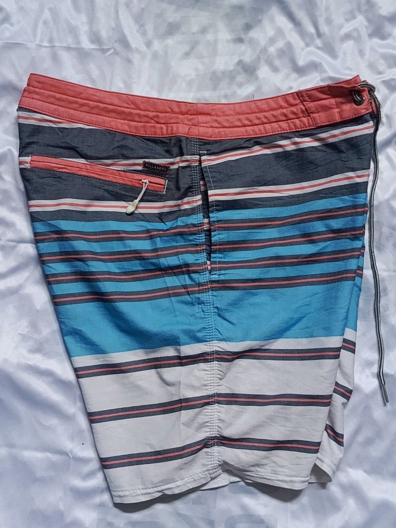 Billabong Striped Board Shorts Size 30 (Category: Swim Trunks & Board Shorts) located in City of Isabela. Submitted by warmbird.d06e6f (Listing ID 1469584182, Image 3). Description: - Brand: Billabong - Size: 30 - Design: Multi-color horizontal stripes (red, navy blue, light blue, and white) - Waistband: Coral pink with drawstring closure and metal eyelets - Pocket: Back zippered pocket with pull tab and branded woven label - Material: 51% cotton