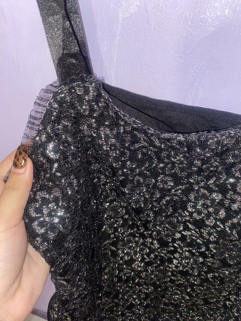 Black and silver sparkly cami tank top (Category: Sleeveless) located in Agdangan. Submitted by ishameicnd (Listing ID 1469640528, Image 2). Description: - Color & Style: Black and silver sparkly cami tank top with a shiny floral lace pattern - Details: Black satin straps and cute ruffle trim along the neckline - Versatility: Perfect for parties, nights out, or easy layering under cardigans and jackets - Condition: Sourced from a friend's wardrob
