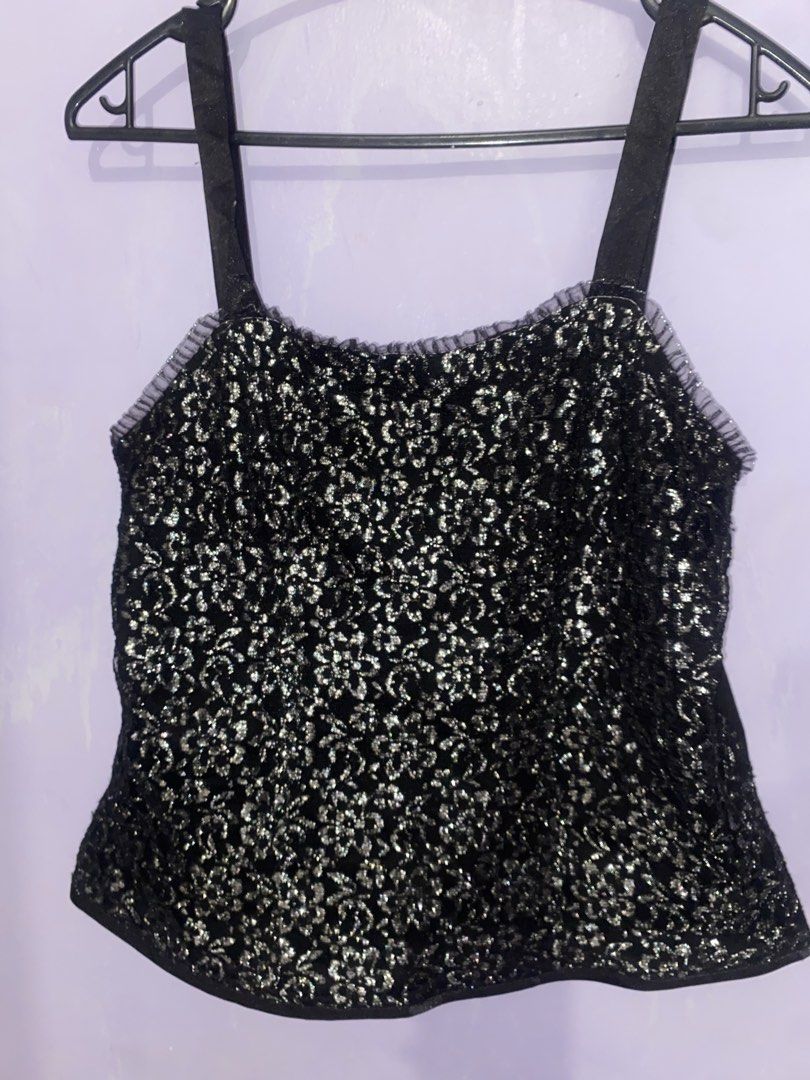 Black and silver sparkly cami tank top (Category: Sleeveless) located in Agdangan. Submitted by ishameicnd (Listing ID 1469640528, Image 1). Description: - Color & Style: Black and silver sparkly cami tank top with a shiny floral lace pattern - Details: Black satin straps and cute ruffle trim along the neckline - Versatility: Perfect for parties, nights out, or easy layering under cardigans and jackets - Condition: Sourced from a friend's wardrob