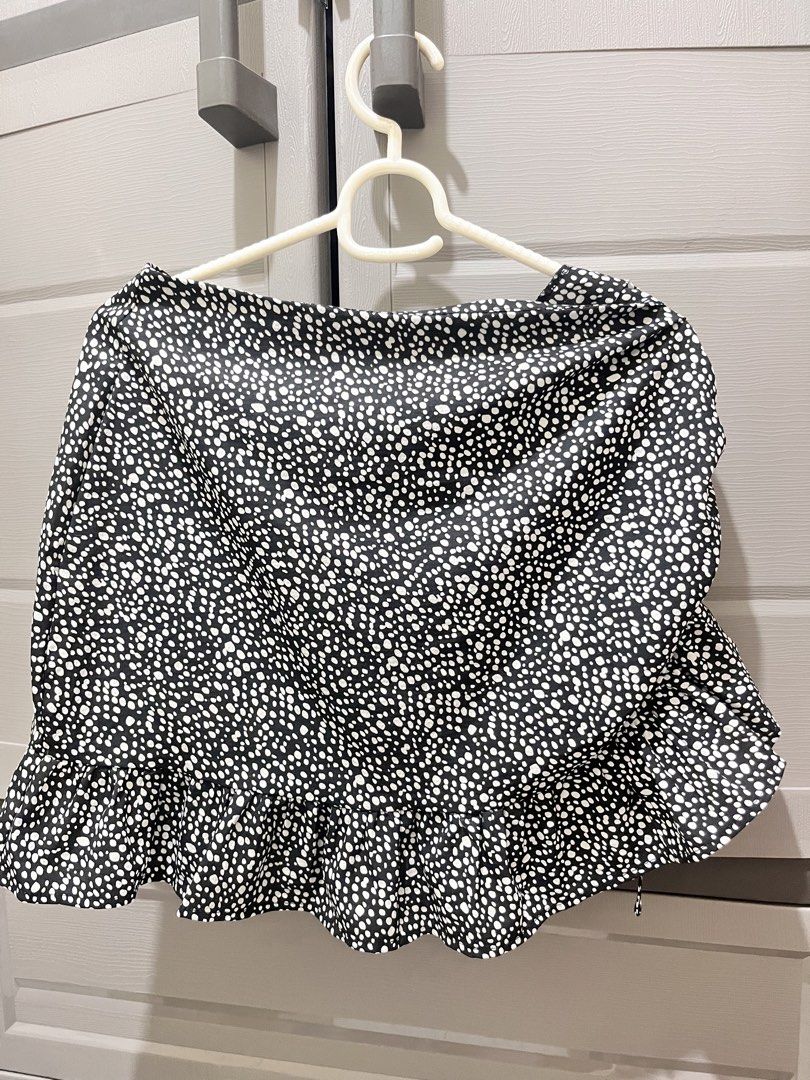 Black and White Polka Dot Ruffle Mini Skirt (Category: Skirts) located in Taguig. Submitted by notyoursam (Listing ID 1469690373, Image 1). Description: - Color/Pattern: Black with tiny white polka dots - Design: Wrap style silhouette with a cute ruffle hem - Material: Lightweight fabric, ideal for warm weather - Styling: Easy to match with basic tops or tees - Condition: Wardrobe clear-out piece.