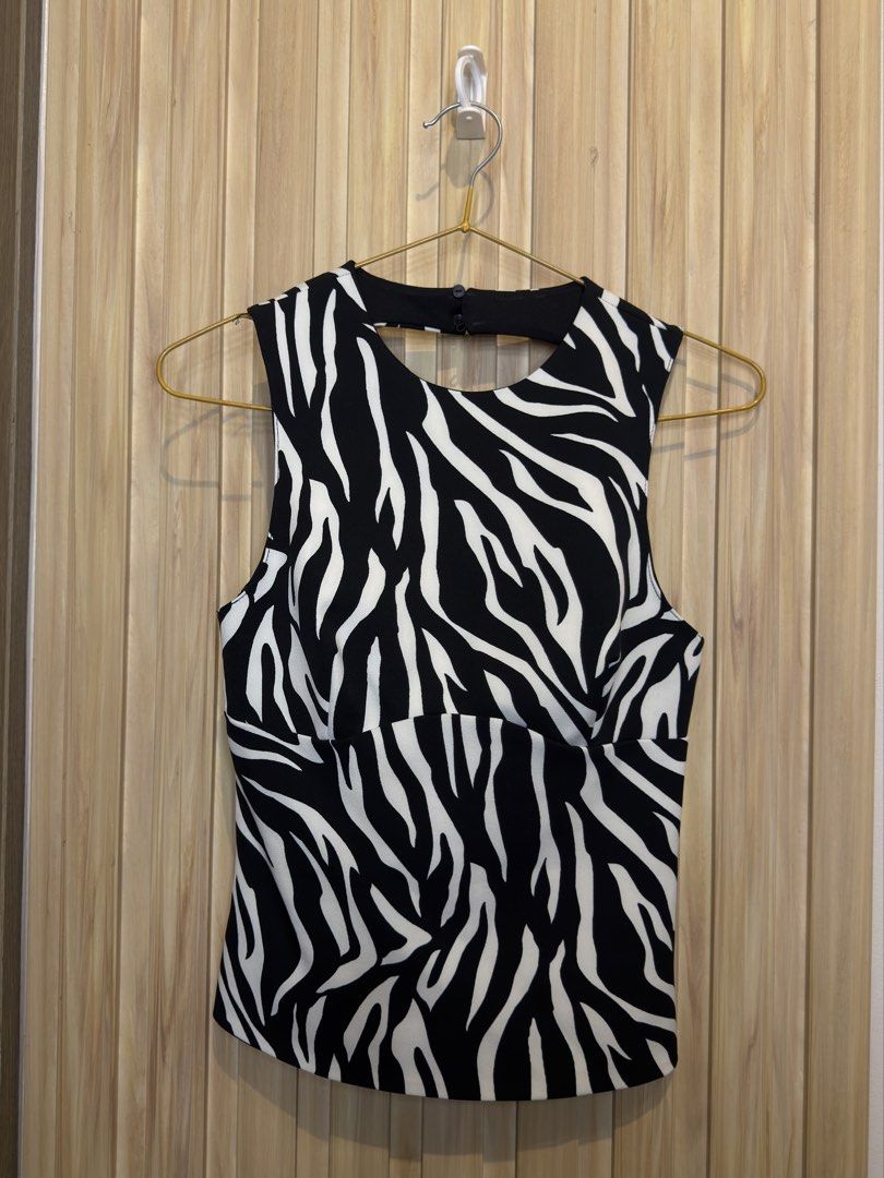 Black and White Zebra Print Sleeveless Top (Category: Sleeveless) located in Manila. Submitted by kyelleanne (Listing ID 1469713227, Image 1). Description: - Style: Black and white zebra print sleeveless top - Fit: Stretchy and snug, highly flattering - Design: High front neckline with button closure, trendy back cutout with straps - Occasion: Ideal for parties and casual nights out - Condition: Excellent, no stains or loose threads -never been u