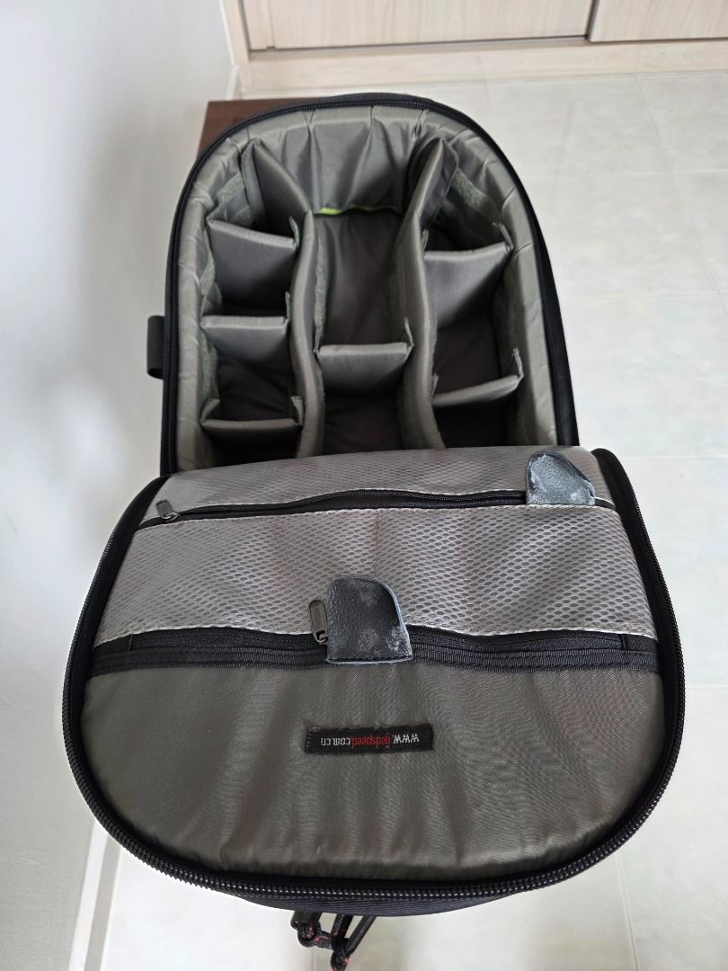 Black Camera Backpack (Category: Camera Bags & Carriers) located in Singapore. Submitted by andlpc2012 (Listing ID 1469701949, Image 2). Description: - Color: Black - Fully adjustable interior padded dividers for bodies and lenses - Multiple exterior pockets and secure bungee strap system - Sturdy top handle and side straps - Clean interior lining with mesh zippered pockets on the flap - Ideal practical gear bag for photographers can hold tripod,