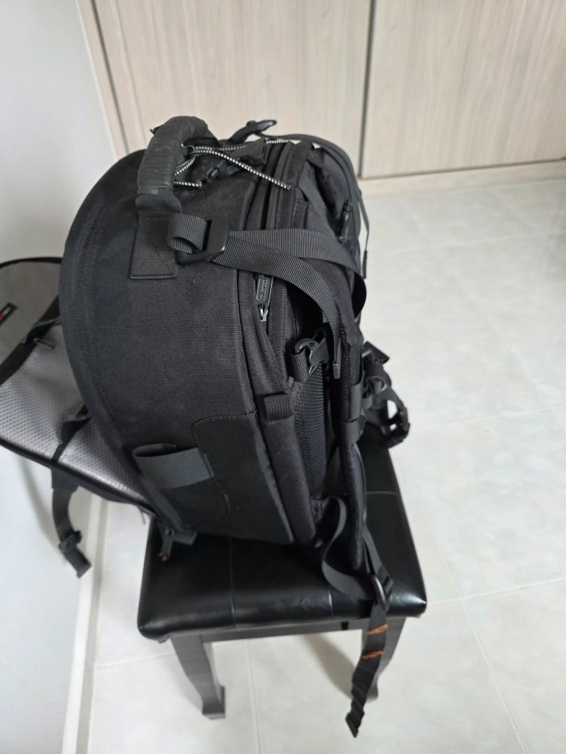 Black Camera Backpack (Category: Camera Bags & Carriers) located in Singapore. Submitted by andlpc2012 (Listing ID 1469701949, Image 3). Description: - Color: Black - Fully adjustable interior padded dividers for bodies and lenses - Multiple exterior pockets and secure bungee strap system - Sturdy top handle and side straps - Clean interior lining with mesh zippered pockets on the flap - Ideal practical gear bag for photographers can hold tripod,