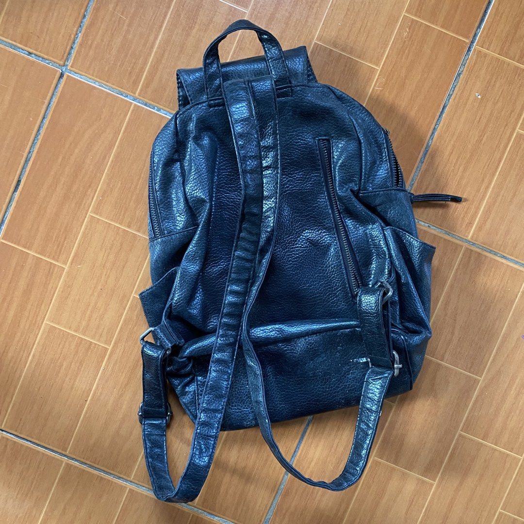 Black Faux Leather Backpack (Category: Backpacks) located in Makati City. Submitted by eunaj (Listing ID 1469660699, Image 2). Description: - Color & Material: Black textured faux leather - Closure: Flap closure with dual zippers - Storage: Roomy main compartment with side pouches and front pocket - Comfort: Adjustable back straps - Condition: Clean interior and solid stitching throughout.