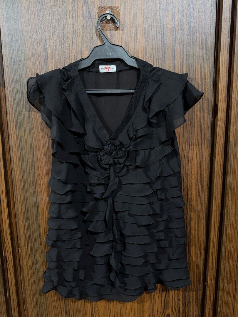 Black layered ruffle chiffon blouse with flower accent (Category: Blouses) located in Quezon City. Submitted by co.coph (Listing ID 1469700970, Image 1). Description: - Color: Black - Material: Lightweight, flowy chiffon with inner torso lining - Design: All-over horizontal ruffles from top to bottom - Neckline: V-neck cut with short ruffled sleeves - Feature: Removable large fabric flower pin at the center chest - Condition: Excellent (Top-rated