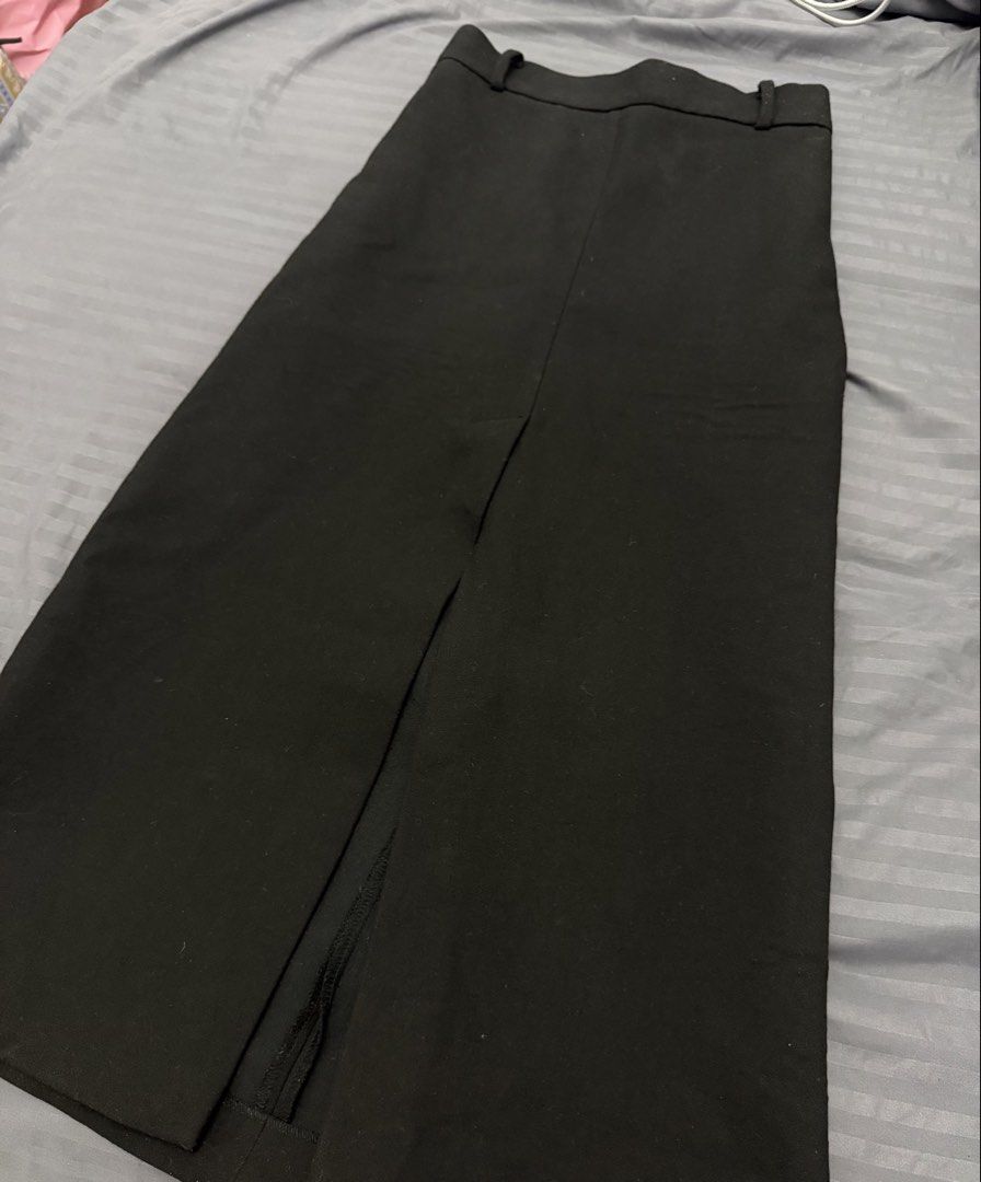 Black midi skirt with front slit (Category: Skirts) located in Manila. Submitted by karminareyes123 (Listing ID 1469685241, Image 1). Description: - small - Color: Black - Length: Midi - Fit: High waisted with built-in belt loops - Detail: Centered front slit at the hem for easy movement - Fabric: Clean and structured - Style: Minimalist, easy to pair with any top - Occasion: Great for office wear or casual outings.