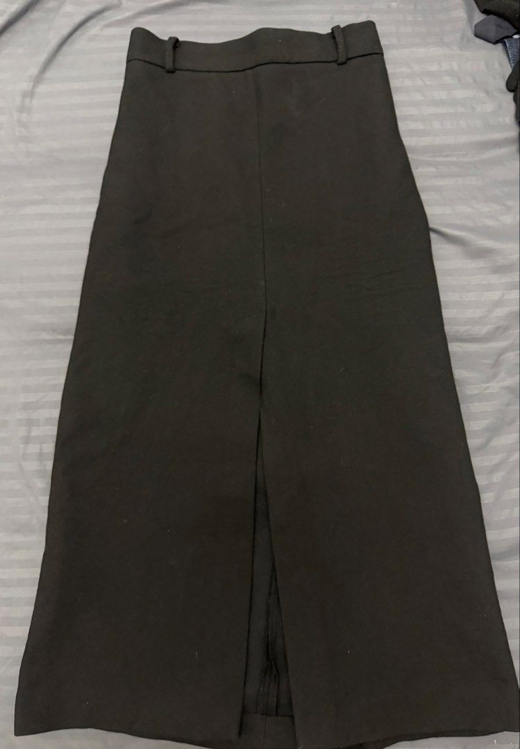 Black midi skirt with front slit (Category: Skirts) located in Manila. Submitted by karminareyes123 (Listing ID 1469685241, Image 3). Description: - small - Color: Black - Length: Midi - Fit: High waisted with built-in belt loops - Detail: Centered front slit at the hem for easy movement - Fabric: Clean and structured - Style: Minimalist, easy to pair with any top - Occasion: Great for office wear or casual outings.