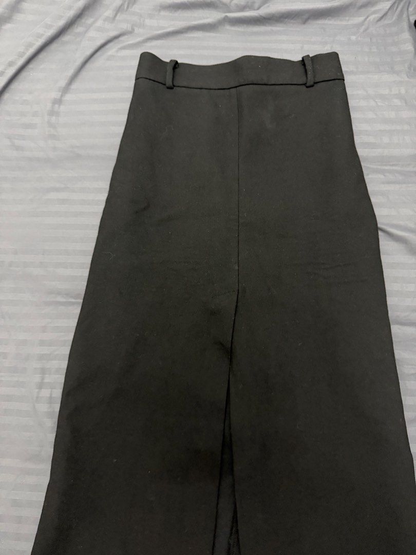 Black midi skirt with front slit (Category: Skirts) located in Manila. Submitted by karminareyes123 (Listing ID 1469685241, Image 2). Description: - small - Color: Black - Length: Midi - Fit: High waisted with built-in belt loops - Detail: Centered front slit at the hem for easy movement - Fabric: Clean and structured - Style: Minimalist, easy to pair with any top - Occasion: Great for office wear or casual outings.
