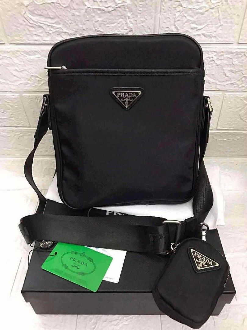 Black Nylon Crossbody Bag with Pouch (Category: Luxury Bags & Wallets) located in Manila. Submitted by prime.dlor (Listing ID 1469743033, Image 1). Description: Black nylon crossbody bag from Prada. Includes a matching mini pouch attached to the wide strap. Front zipper pocket with the enamel triangle logo plaque. Main compartment has a zip closure and signature jacquard lining. Silver-tone hardware throughout. Original box, dust bag, and green a