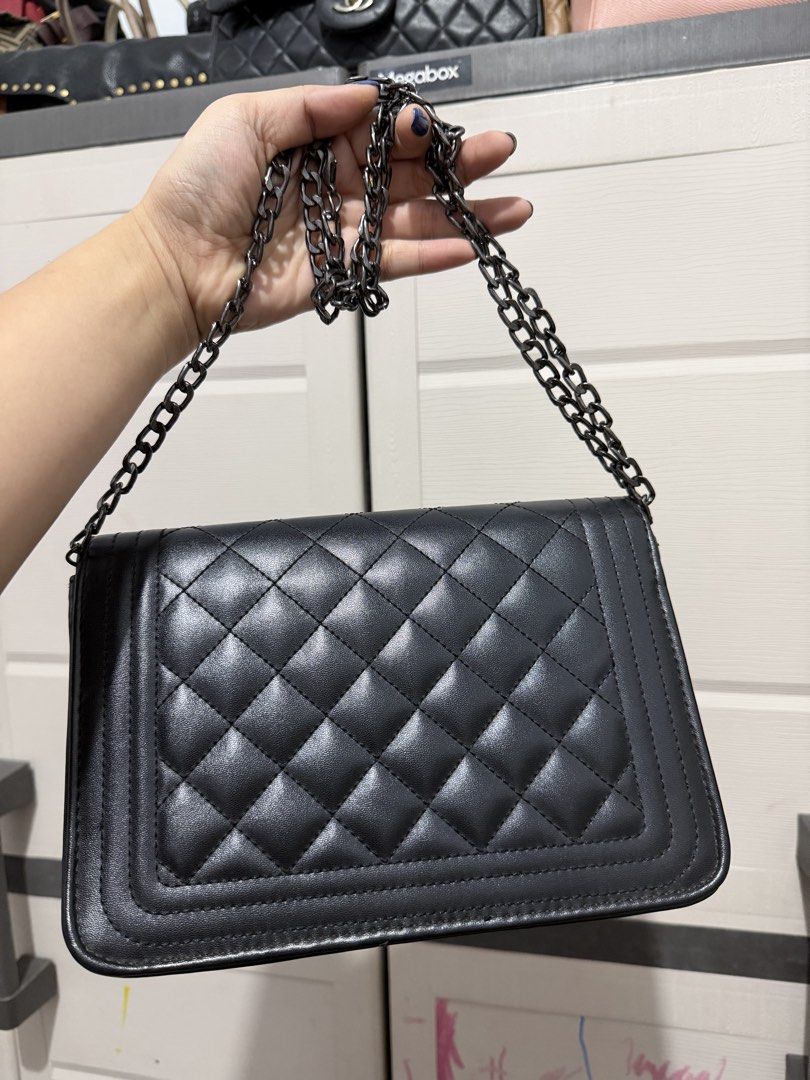 Black Quilted Crossbody Bag with Chain Strap (Category: Cross-body Bags) located in Quezon City. Submitted by skyleeeee (Listing ID 1469583686, Image 2). Description: - Color & Material: Classic black soft faux leather - Hardware & Closure: Gunmetal hardware with a secure turn-lock flap closure - Strap: Sturdy, adjustable dark chain shoulder strap - Interior: Clean lining complete with a handy slip compartment - Condition: Minimal wear on corners