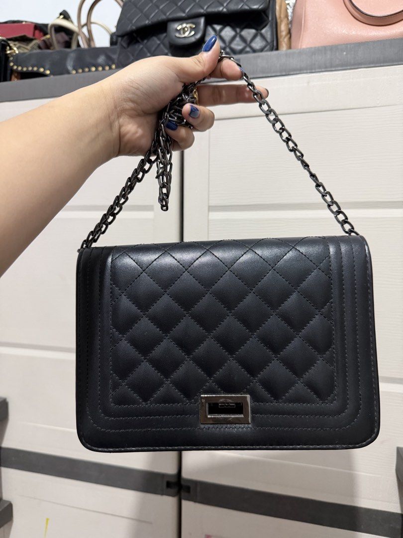 Black Quilted Crossbody Bag with Chain Strap (Category: Cross-body Bags) located in Quezon City. Submitted by skyleeeee (Listing ID 1469583686, Image 1). Description: - Color & Material: Classic black soft faux leather - Hardware & Closure: Gunmetal hardware with a secure turn-lock flap closure - Strap: Sturdy, adjustable dark chain shoulder strap - Interior: Clean lining complete with a handy slip compartment - Condition: Minimal wear on corners