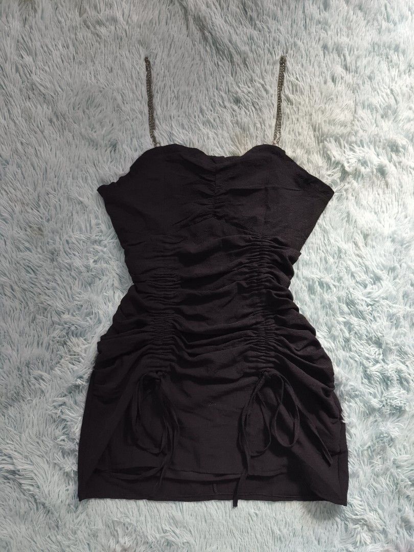 Black ruched mini dress with chain straps (Category: Dresses) located in Quezon City. Submitted by alluring.avenue (Listing ID 1469599897, Image 1). Description: - Color: Classic black - Style: Mini dress with a flattering sweetheart neckline - Details: Front and side ruching with adjustable hem drawstrings - Straps: Chic silver metal chain shoulder straps - Fit: True to size with a stretchy, body-hugging fabric - Occasion: Ideal for parties, clu
