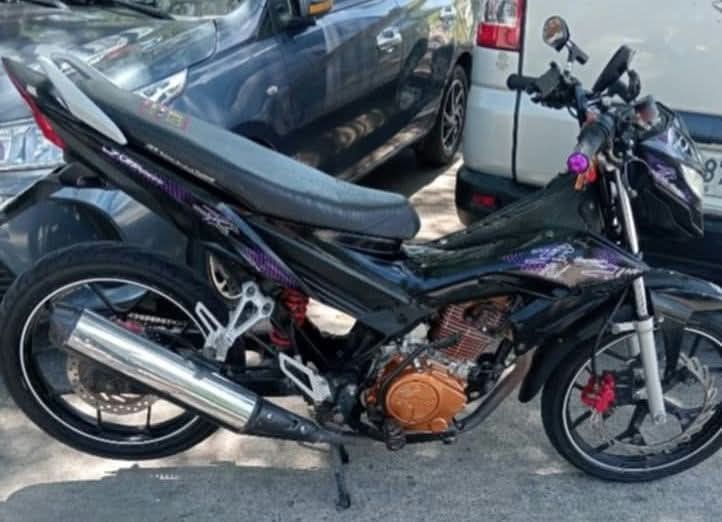 Black Underbone Motorcycle with Chrome Exhaust (Category: Motorbikes for Sale) located in Paranaque City. Submitted by khena (Listing ID 1469707819, Image 1). Description: Black underbone motorcycle, purple graphic accents on the body. Copper-colored engine crankcase cover. Red brake caliper on the front disc wheel. Silver alloy wheels, standard rear suspension with red spring. Chrome exhaust pipe running along the right side. Black single-piece 