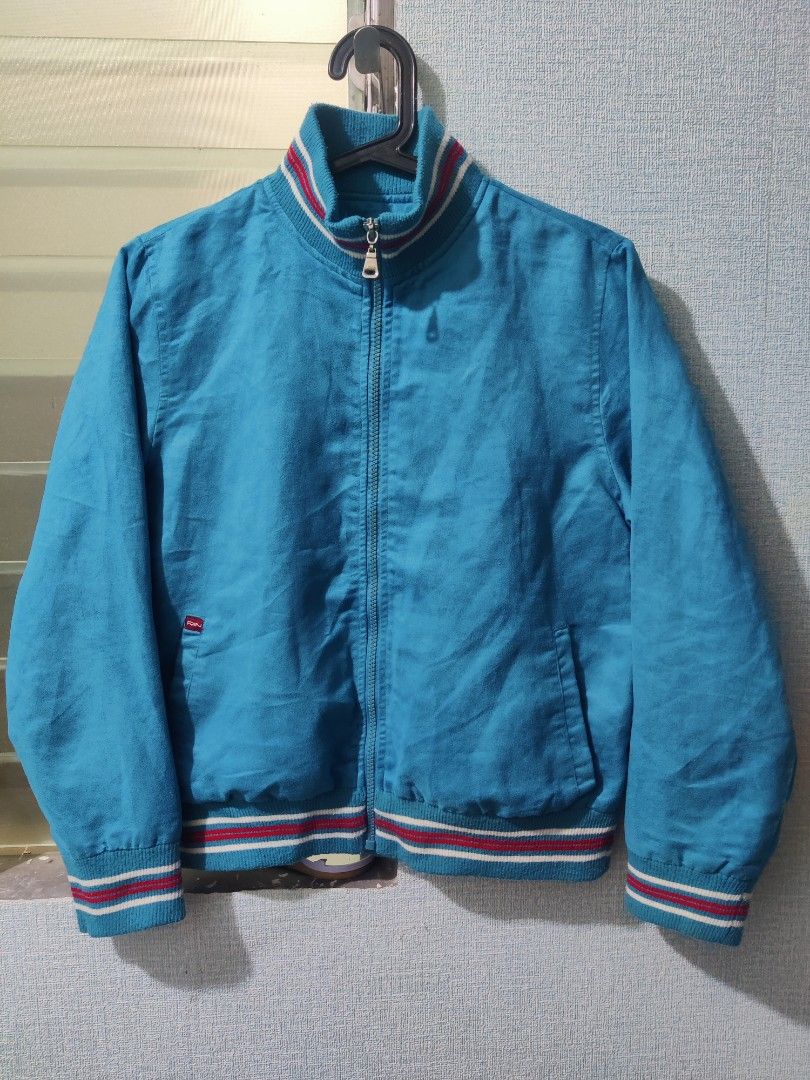Retro Blue Jacket (Category: Coats, Jackets and Outerwear) located in Pasig City. Submitted by shiyenaaa (Listing ID 1469669183, Image 1). Description: - Color: Bright blue with red and white striped ribbed collar, cuffs, and hem - Material: Soft and comfortable fabric texture - Closure: Full front zipper with a metallic pull tab - Pockets: Two front slash pockets - Details: Small red tag near the right pocket - Style: Casual vintage vibe, great 