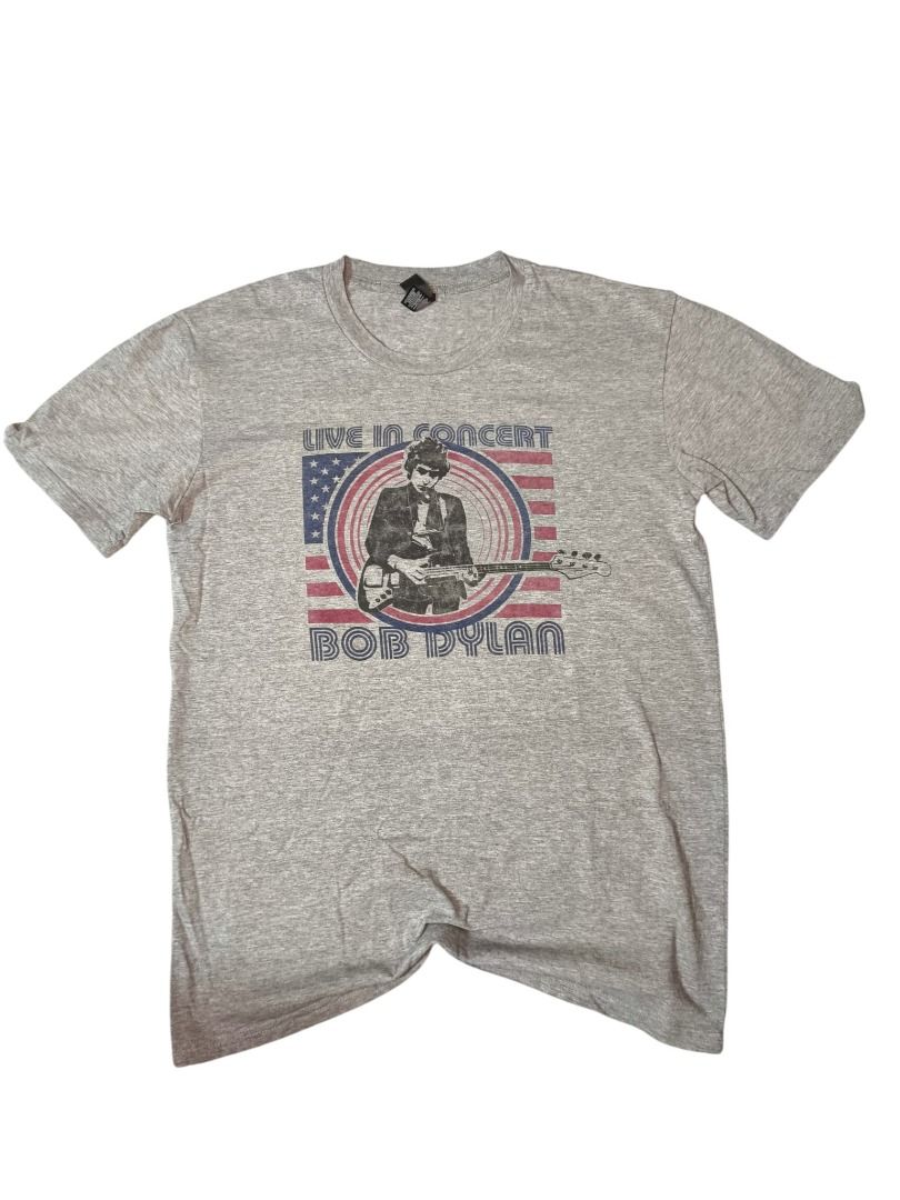 Bob Dylan Live in Concert Graphic Tee (Category: Tshirts & Polo Shirts ) located in Baguio. Submitted by boneteezandharmony (Listing ID 1469664288, Image 1). Description: Heather grey graphic tee featuring Bob Dylan with his guitar, framed by a vintage-inspired American flag design. A great casual piece for music lovers and fans of classic rock and folk. Condition: 9/10 Dimes: Approx. 19W × 28L.