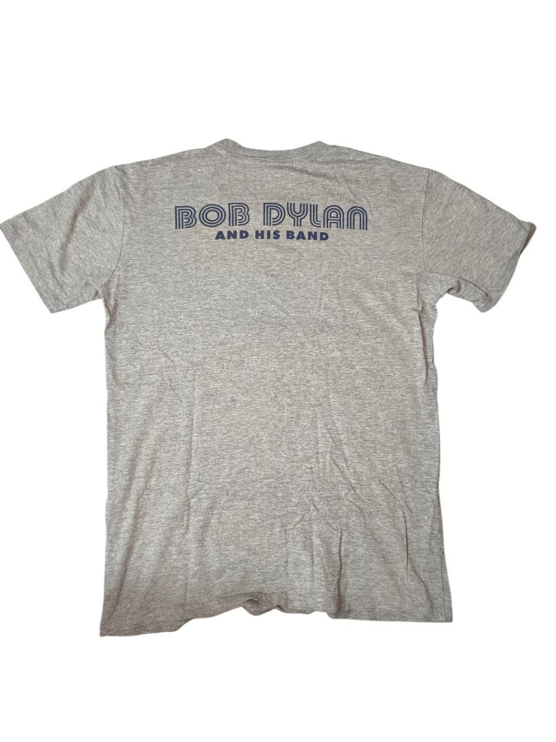 Bob Dylan Live in Concert Graphic Tee (Category: Tshirts & Polo Shirts ) located in Baguio. Submitted by boneteezandharmony (Listing ID 1469664288, Image 2). Description: Heather grey graphic tee featuring Bob Dylan with his guitar, framed by a vintage-inspired American flag design. A great casual piece for music lovers and fans of classic rock and folk. Condition: 9/10 Dimes: Approx. 19W × 28L.