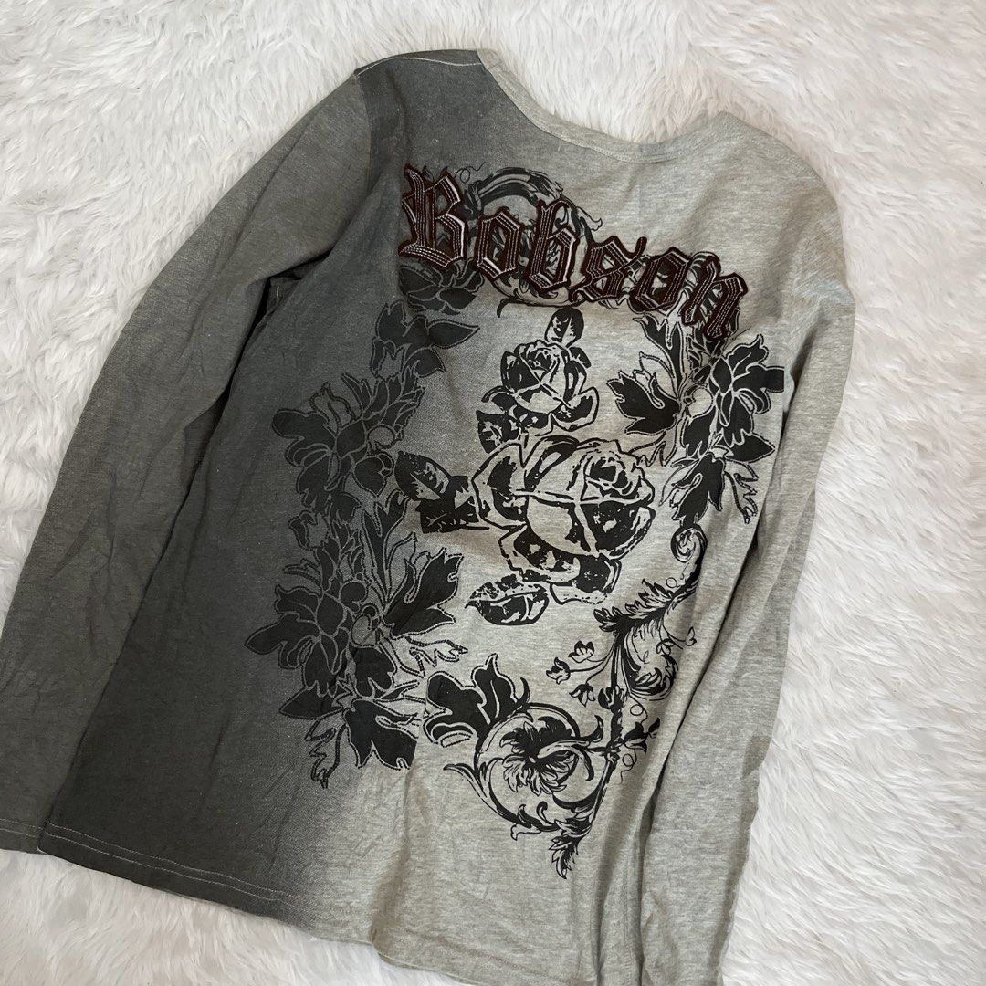 Bobson Grey Graphic Long Sleeve Top (Category: Longsleeves) located in Maasin. Submitted by taraa18 (Listing ID 1469583803, Image 3). Description: - Brand/Model: Bobson long sleeve top - Color: Grey - Size: Tag size L - Neckline: Scoop neckline - Design: Dark floral print graphics down one side and back - Detailing: Embroidered gothic lettering across chest and upper back.