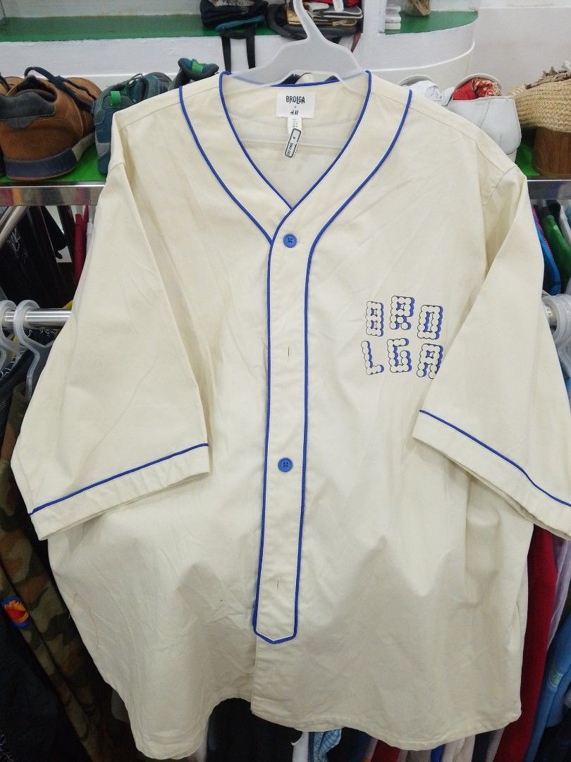 Brolga H&M Cream Blue Baseball Jersey (Category: Activewear) located in Manila. Submitted by afreemf (Listing ID 1469644145, Image 1). Description: - Color: Cream with blue trim and matching buttons - Design: Brolga chest graphic and large blue 'Brolga' script lettering across the back - Fit: Relaxed short-sleeve fit - Style: Ideal for casual everyday streetwear looks - Condition: Brand new/Excellent.