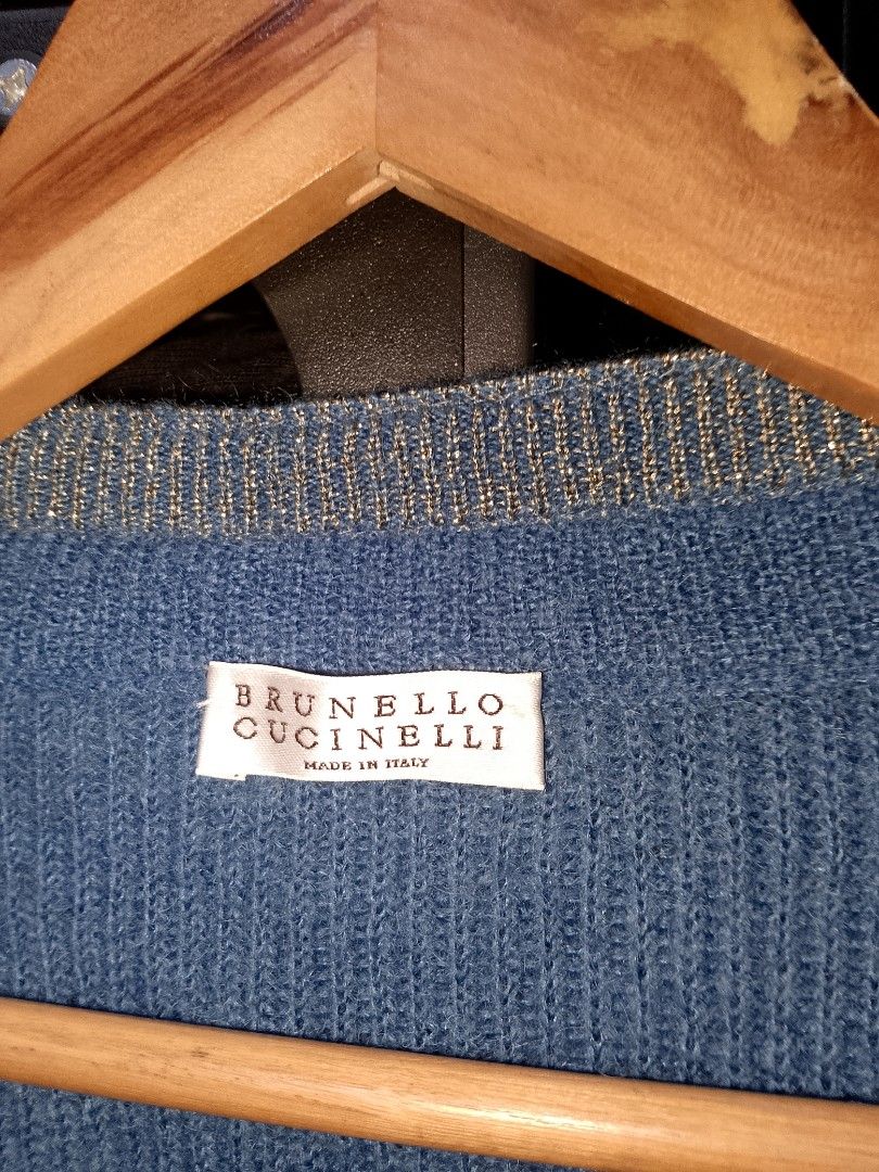 Brunello Cucinelli Blue Mohair Cardigan (Category: Coats, Jackets and Outerwear) located in Manila. Submitted by mjthrifted_second (Listing ID 1469643116, Image 3). Description: - Brand: Brunello Cucinelli - Origin: Made in Italy -Size: Large -Dimes: 21/26 - Material: Luxurious mohair, virgin wool, and polyamide blend - Design: Blue knit cardigan with elegant shimmery trim along the V-neck and button placket - Features: Long sleeves, ribbed cuffs