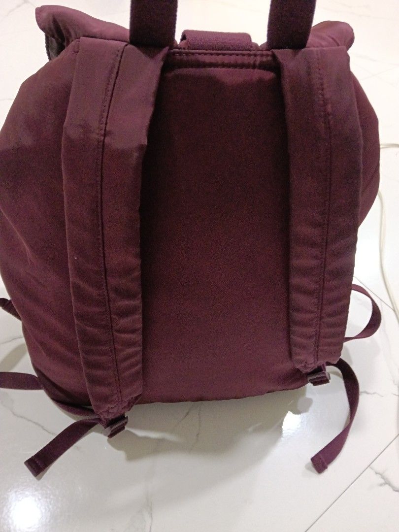 Burgundy nylon rucksack backpack with front pockets and buckle closure (Category: Backpacks) located in Manila. Submitted by zenbear_6b2d8a (Listing ID 1469586498, Image 3). Description: - Color: Stylish burgundy - Material: Durable nylon with pale pink fabric interior - Closure: Secure drawstring with patterned cord and heavy-duty plastic buckle flap - Storage: Main compartment, interior zippered pocket, and two front buckle pockets - Comfort: A