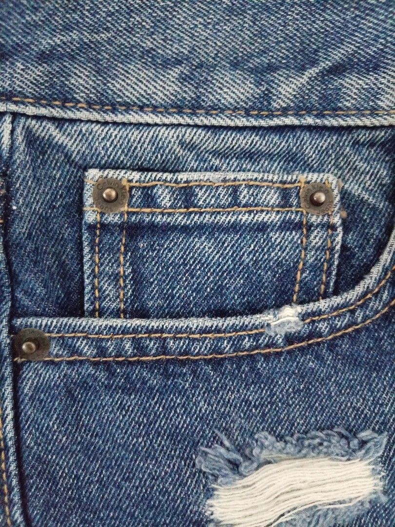Calvin Klein Jeans Distressed Denim Shorts (Category: Shorts) located in Las Pinas. Submitted by bettybellv (Listing ID 1469667355, Image 3). Description: - Brand: Calvin Klein Jeans - Style: High-waist denim shorts - Wash: Medium wash with distressed details and frayed side hems - Details: Front button closure, branded hardware, and classic five-pocket design - Branding: Signature leather patch on the back waistband and small black logo label on
