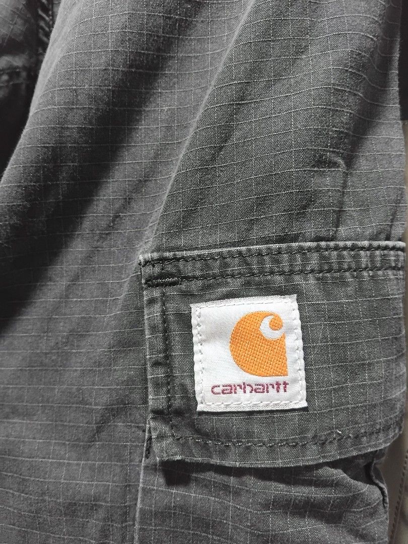 Carhartt WIP Regular Cargo Pant Dark Grey (Category: Jeans) located in Manila. Submitted by fiercehorse-60ca (Listing ID 1469598782, Image 3). Description: - Brand: Carhartt WIP - Style: Regular Cargo Pants - Color: Dark Grey - Material: Durable Ripstop Fabric - Size: 33 x 32 - Origin: Made in Tunisia - Features: Multiple utility pockets, reinforced knee panels, rear seat patch, and button fly closure - Branding: Iconic woven square Carhartt logo